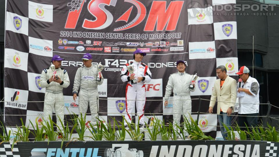 Pebalap ABM Motorsport, Paul Montolalu (tengah) saat di podium usai memenangi kelas Ferrari F430 pada Kejuaraan Indonesian Sentul Series of Motorsport (ISSOM) 2014 di Sirkuit Internasional Sentul, Minggu (30/11/14). - INDOSPORT